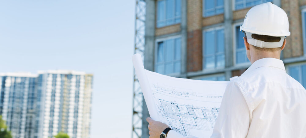 back-view-man-holding-building-plans